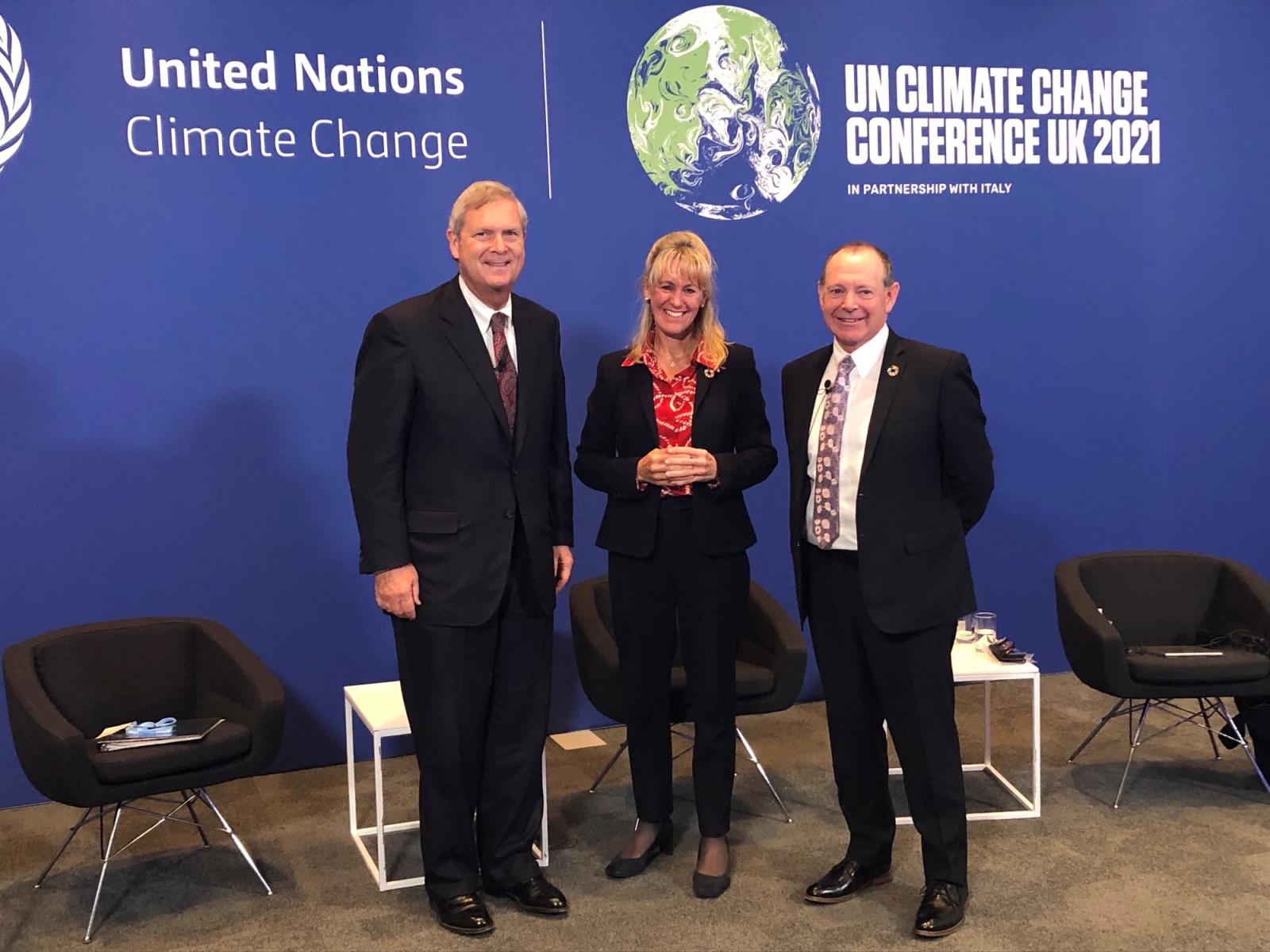 Secretary Vilsack and other panelists in front of COP26 background