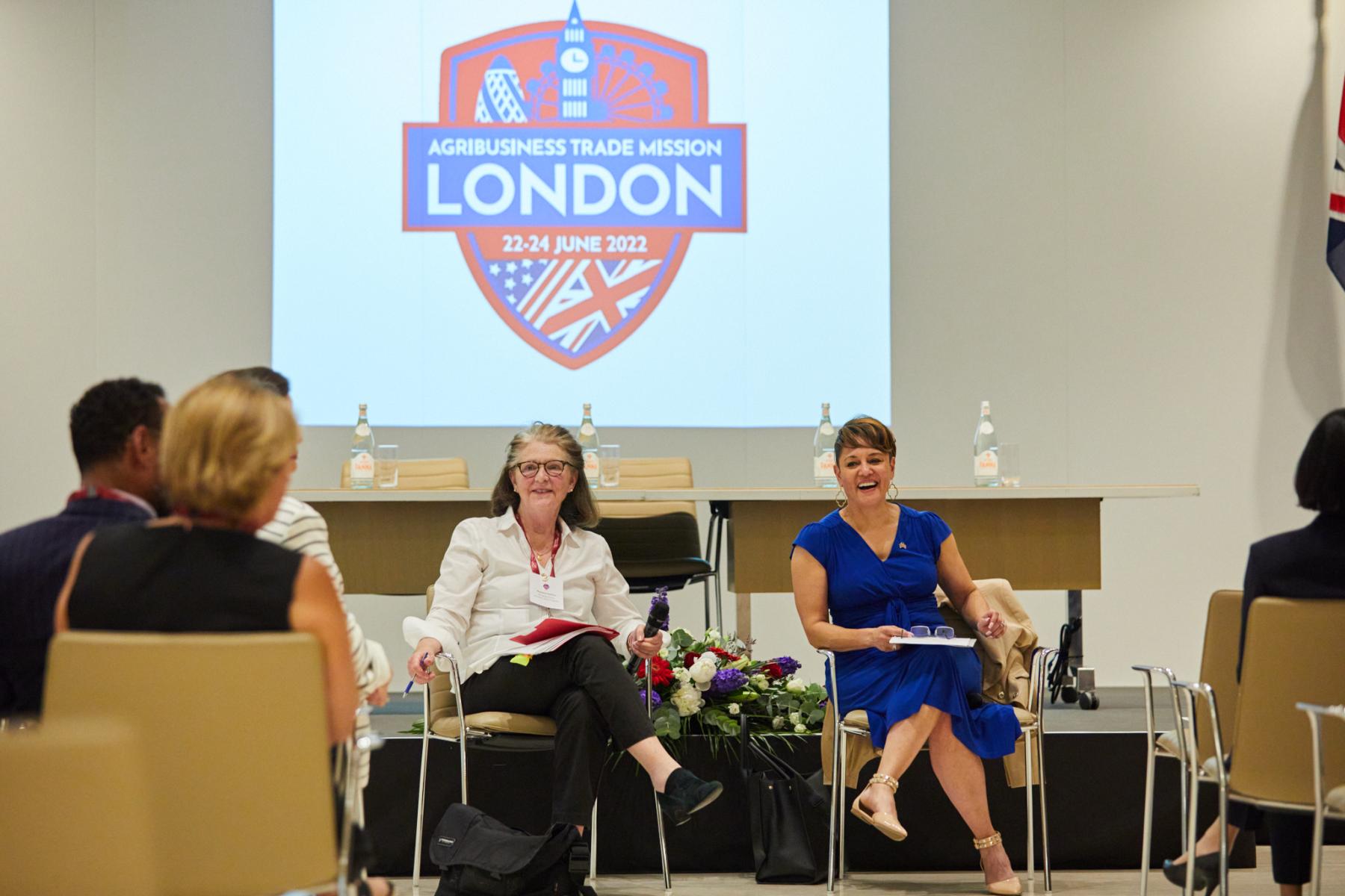 Women in front of screen with trade mission logo