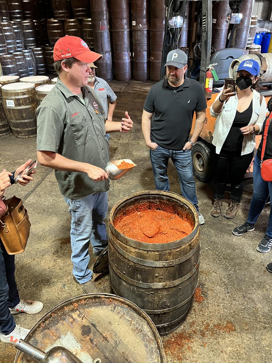 Mr. Christian Brown, Agriculture Manager & McIlhenny family member for Tabasco at Avery Island, LA, shares pepper mash, which is more concentrated and spicier than bottled Tabasco, with FAS overseas staff at the mash warehouse.