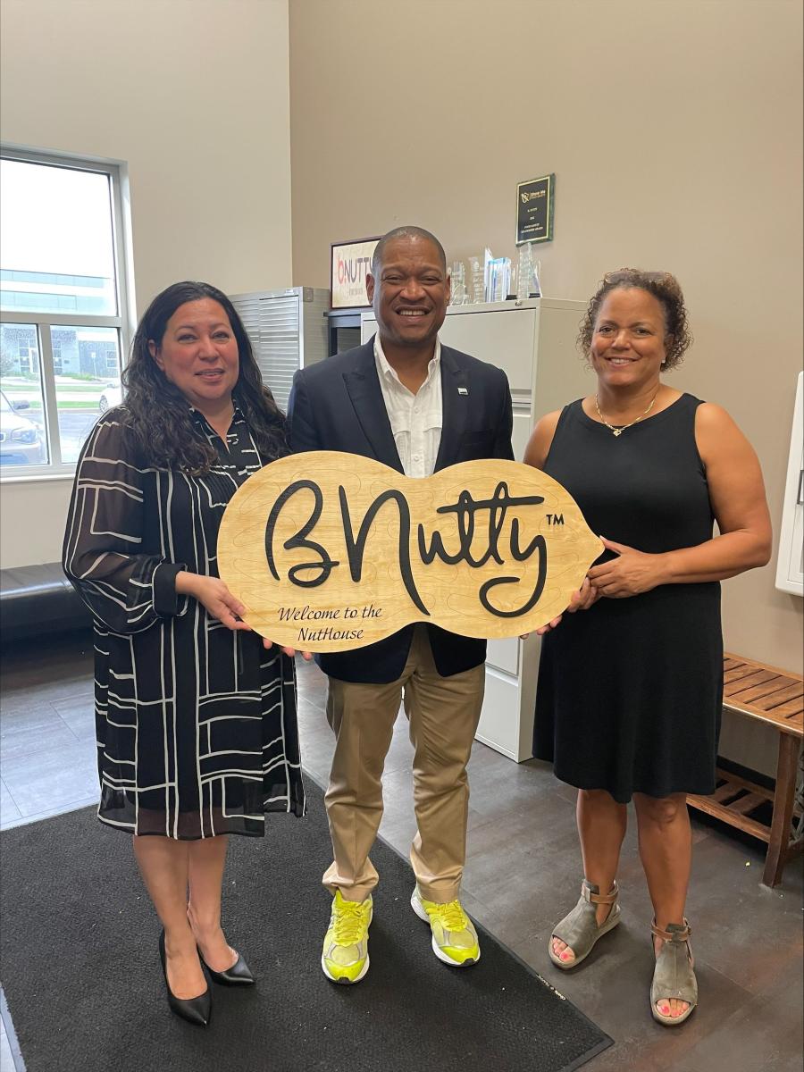 FAS Administrator Daniel Whitley holds up peanut shaped sign for BNutty with its female owners, Carol Podolak and Joy Thompkins.