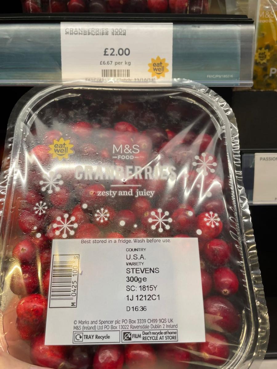 A plastic-wrapped package of fresh cranberries.