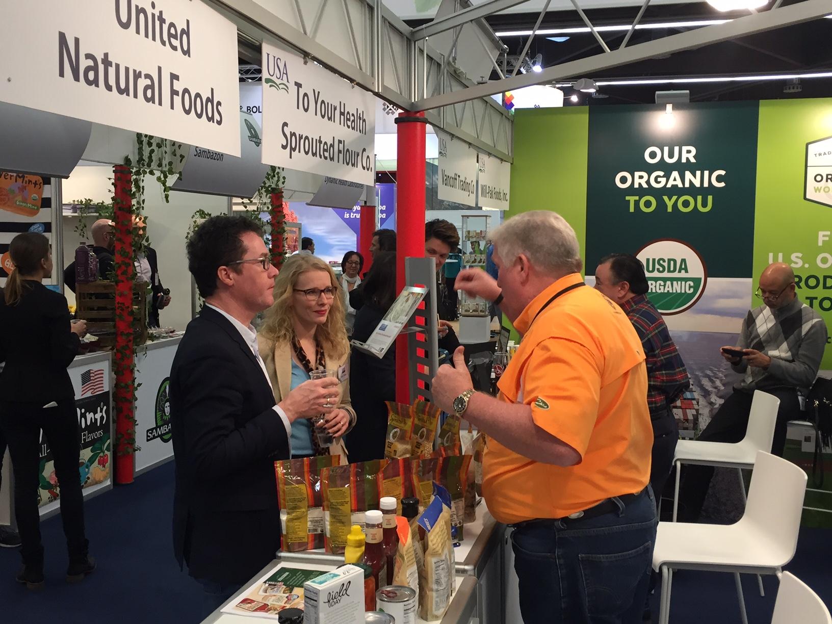 Harald Ebner, Member of German Parliament, tours the USA Pavilion with Kelly Stange, Agricultural Counselor at the U.S. Embassy in Berlin, and meets Jeff Sutton, CEO of To Your Health Sprouted Flour Co. from Alabama.