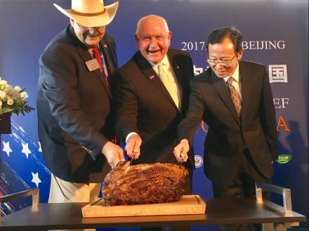 U.S. Secretary of Agriculture Sonny Perdue (center) ceremonially cuts into a Nebraska prime rib in Beijing, marking the return of U.S. beef to the Chinese market. Perdue is joined by Craig Uden (left), president of the National Cattlemen's Beef Associatio