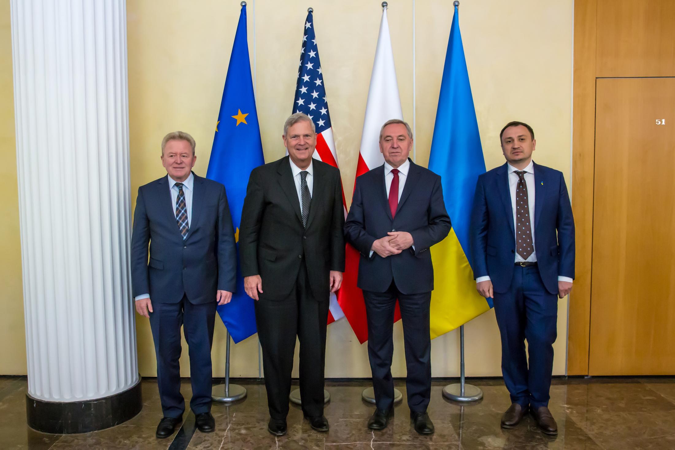 4 agriculture ministers standing in front of flags